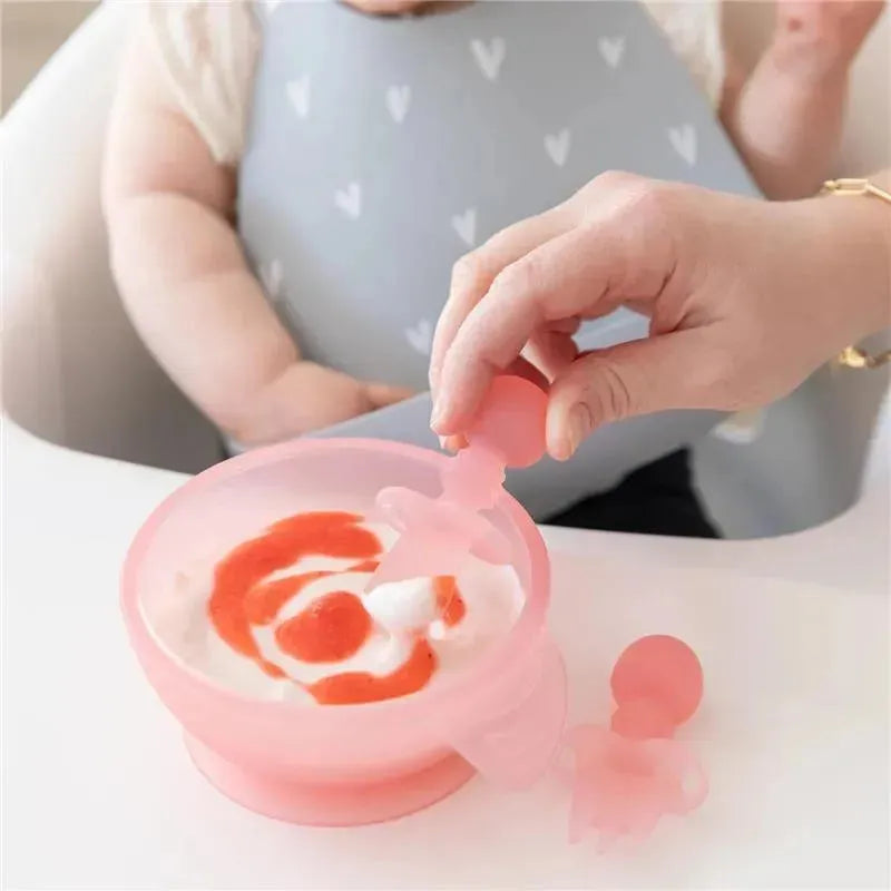 Bumkins Baby Utensils Set, featuring pink silicone spoon and bowl, with yogurt and sauce for toddler mealtime.