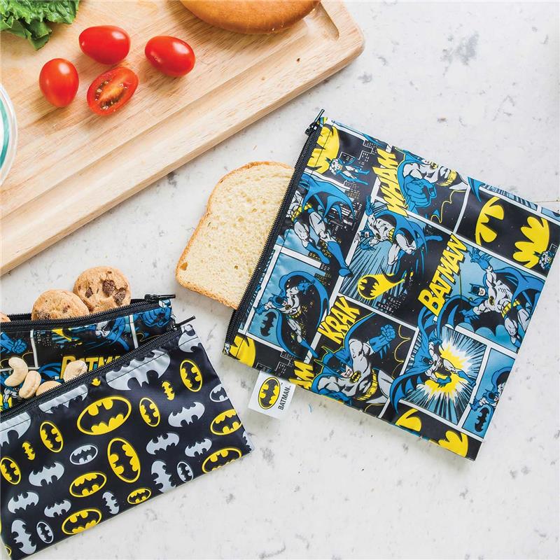 Large Bumkins DC Comics reusable snack bag featuring Batman comic designs, alongside slices of bread and cookies.