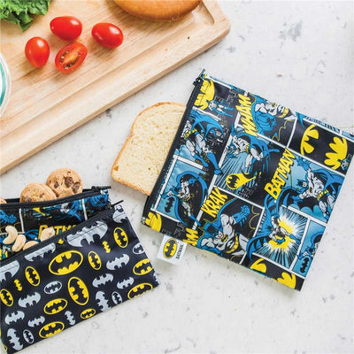 Large Bumkins DC Comics reusable snack bag featuring Batman comic designs, alongside slices of bread and cookies.