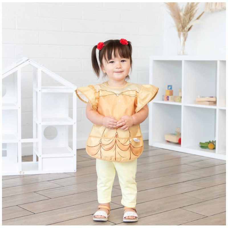 Bumkins Disney Princess Ruffle Apron Bib in Belle design worn by a young girl, featuring golden fabric and ruffled sleeves.