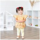 Bumkins Disney Princess Ruffle Apron Bib in Belle design worn by a young girl, featuring golden fabric and ruffled sleeves.