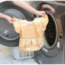 Disney Princess Ruffle Apron Bib featuring Belle, being held near a washing machine, showcasing its vibrant yellow color and design.