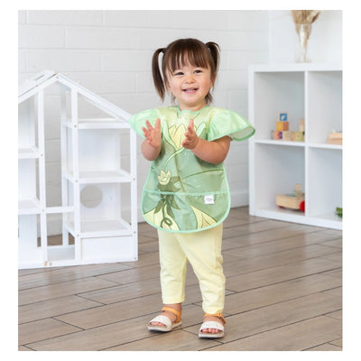 Bumkins Disney Ruffle Apron Bib featuring Tiana design, worn by a smiling child with pigtails, clapping hands.