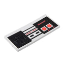 Silicone teether designed to resemble a classic Nintendo controller, featuring black and red button details.