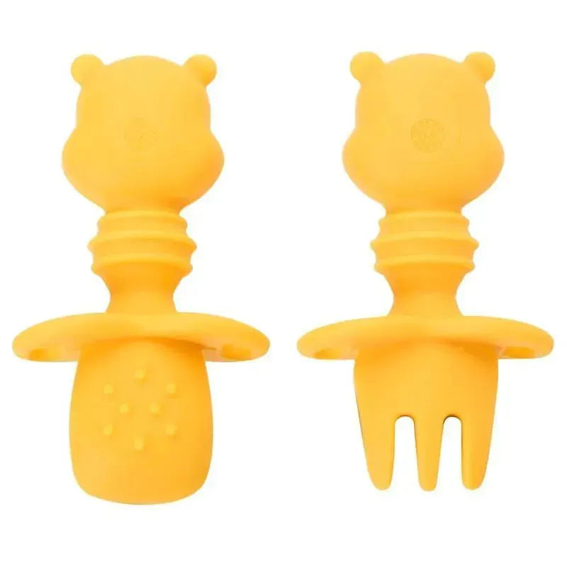 Yellow silicone chewing utensils, designed for toddlers, featuring a spoon and fork with bear-shaped handles.