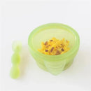 Bumkins silicone feeding set in green jelly, featuring a suction bowl filled with food and a matching spoon.