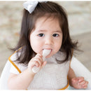 Bumkins Silicone First Feeding Set in sand color, featuring a toddler holding a spoon, wearing a bib.