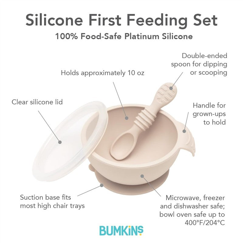 Silicone first feeding set in sand color, includes bowl, clear lid, and double-ended spoon, made of food-safe silicone.