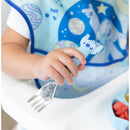 Bumkins Spoon + Fork with a blue Stitch character grip, held by a child in a colorful bib.