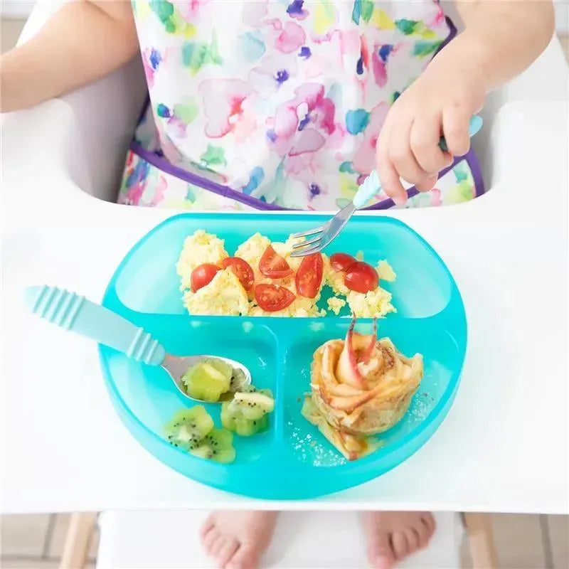 Bumkins Silicone Grip Dish in blue holding scrambled eggs, cherry tomatoes, kiwi pieces, and a pastry, with child using utensils.