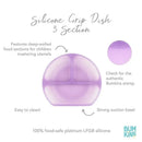 Purple silicone grip dish with three sections, designed for children mastering utensils, featuring a strong suction base.