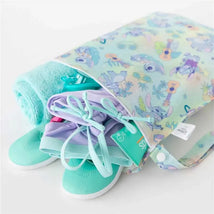 Bumkins Aloha Wet Bag with colorful tropical design, holding a towel, swimwear, and aqua flip-flops.