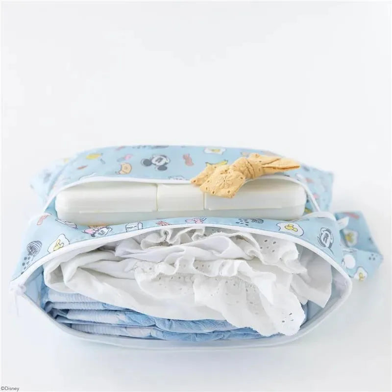 Wet/dry clutch bag featuring Mickey and Minnie Mouse designs, filled with neatly folded clothing and a pack of wipes.