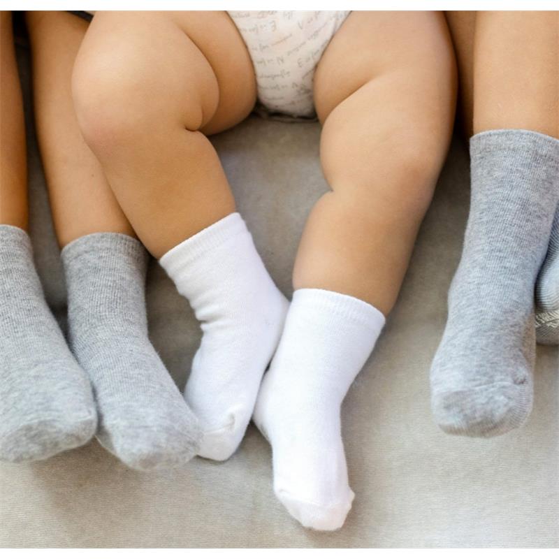 Solid organic cotton baby crew socks in white and grey, displayed on small feet, with a light grey background.