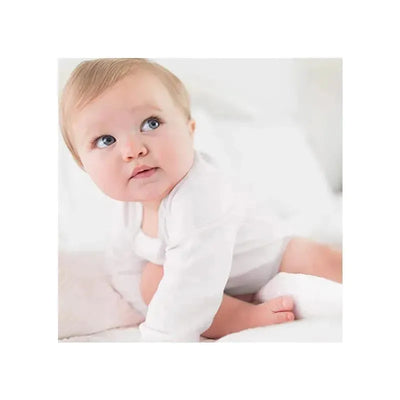 Baby wearing a white long sleeve bodysuit, looking curiously while sitting on soft blankets.