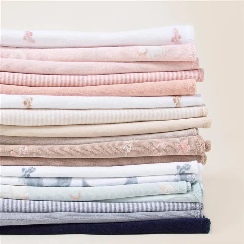 Set of 5 solid burp cloths in pink sand, featuring various pastel colors and soft floral patterns, neatly stacked.