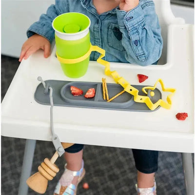 Busy Baby Mini Mat in spearmint color equipped with food, cup, and utensils in a high chair setting.
