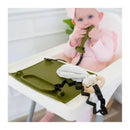Baby sitting in a high chair, playing with a Spearmint Busy Baby Toy Bungee and a silicone placemat, with a soft cloth nearby.