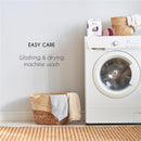 Nursing pads packaging beside a washing machine with a laundry basket and text on easy care instructions.