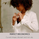 A woman in a white shirt is inserting a beige nursing pad into her top, showcasing its ergonomic, discreet, and non-slip design.