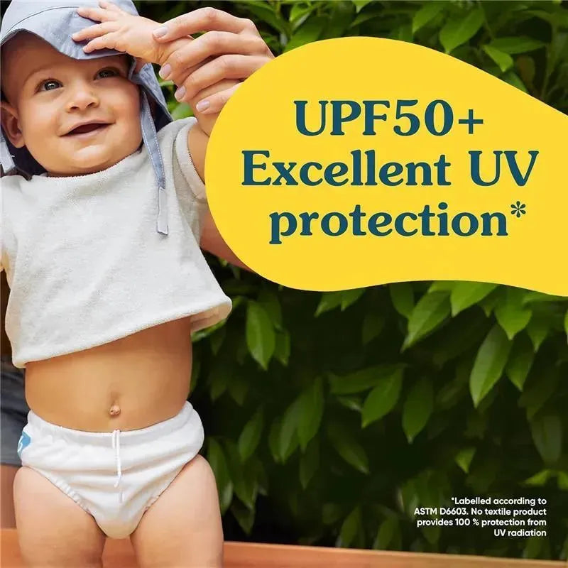 Reusable swim diaper in white worn by a smiling baby, held by an adult, with a background of green leaves. UPF50+ UV protection text visible.