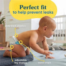 Reusable cloth diaper on a crawling baby, highlighting features like wide back elastics, adjustable leg elastics, and waist snaps.