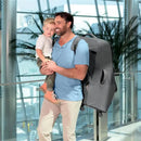 A man carrying a boy in a travel setting, with a Chicco Car Seat Travel Bag in anthracite on his back.