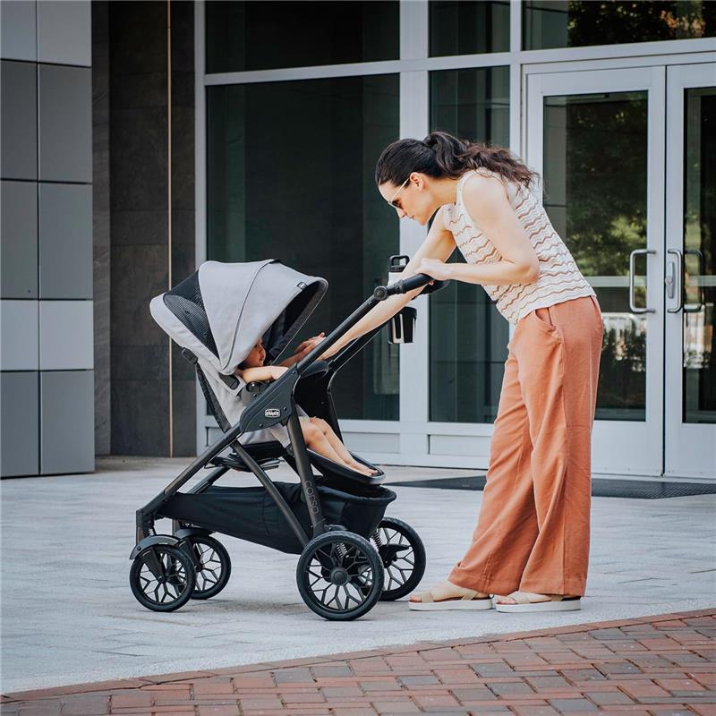 Chicco Corso LE ClearTex Modular Travel System in Tidal color, featuring a woman interacting with a child in the stroller outdoors.