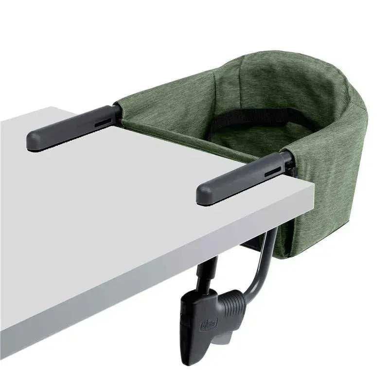 Chicco Fastlock 360 Hook-On Chair in Moss, securely attached to a table, featuring a soft fabric seat and sturdy clamps.