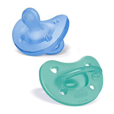 Two Chicco Physioforma orthodontic silicone pacifiers in blue and green, designed for infants 6-16 months, featuring heart-shaped vents.
