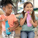 Two children sitting together outdoors, one holding a pink Chicco insulated water bottle and the other a blue bottle, both smiling.