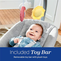 Baby in a gray Chicco Float Baby Seat smiles while reaching for a removable toy bar featuring plush cloud and sun toys.