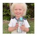 Child holding a Chicco Insulated Flip-Top Straw Cup in Silver/Blue Sunburst, smiling outdoors.