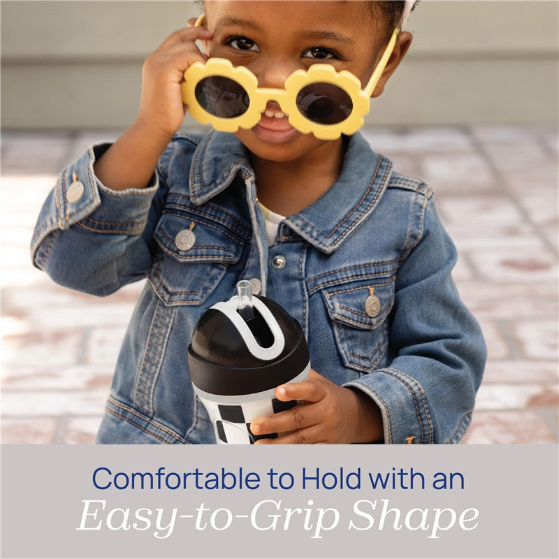 Toddler with yellow sunglasses holding a Chicco Insulated Straw Sippy Cup, featuring a spill-free flip-top lid.