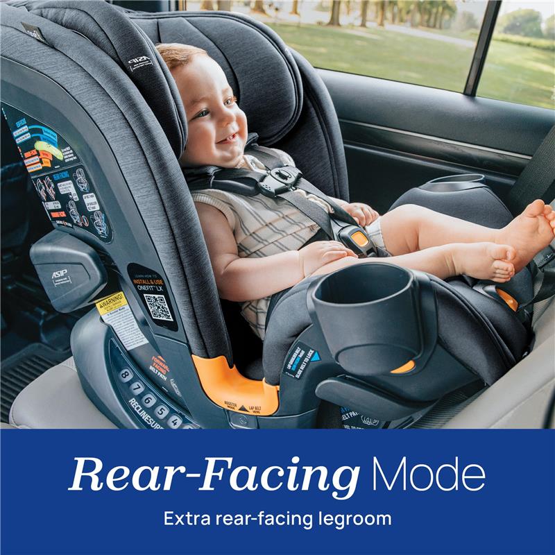 Chicco OneFit LX ClearTex All-in-One Car Seat in rear-facing mode with a smiling baby seated inside, showcasing legroom and safety features.