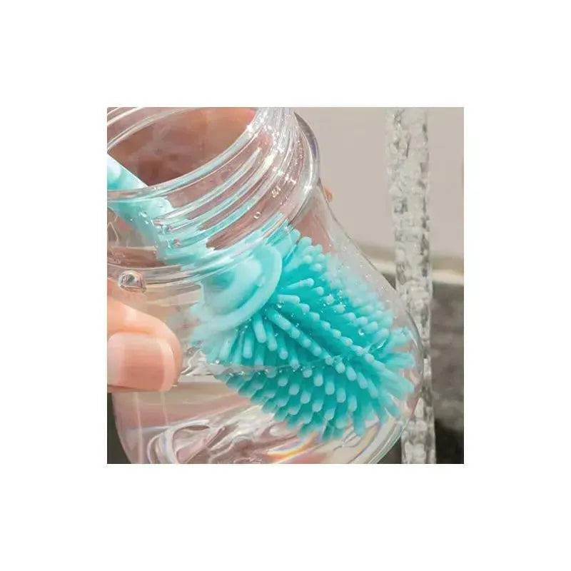 Chicco Silicone Bottle Brush in use, showing soft bristles and handle submerged in water for cleaning.
