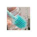 Chicco Silicone Bottle Brush in use, showing soft bristles and handle submerged in water for cleaning.