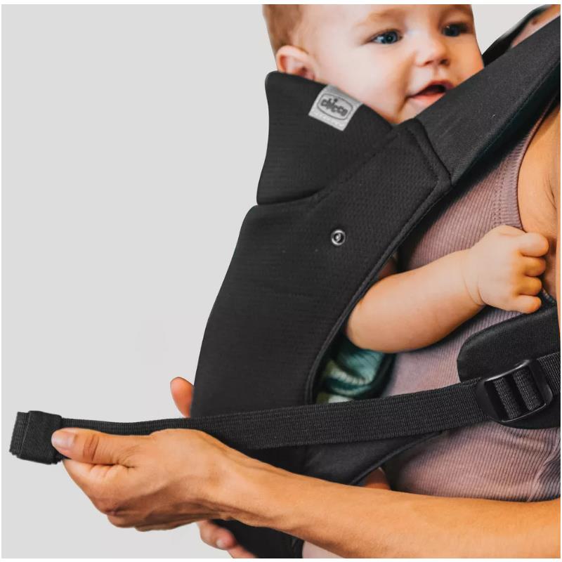 Chicco Snugsupport 4-In-1 Infant Carrier in black, featuring a child being securely held, with adjustable straps visible.