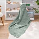 Hooded towel in fern color draped over a child sitting on the floor, surrounded by toys and a shelf of books.
