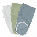 Three pastel-colored swaddle blankets in stone, sage green, and pacific blue, featuring zipper closures and rounded corner designs.
