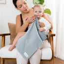 A woman gently wipes the face of a baby with a light blue burp cloth, showcasing the Comfy Cubs brand.