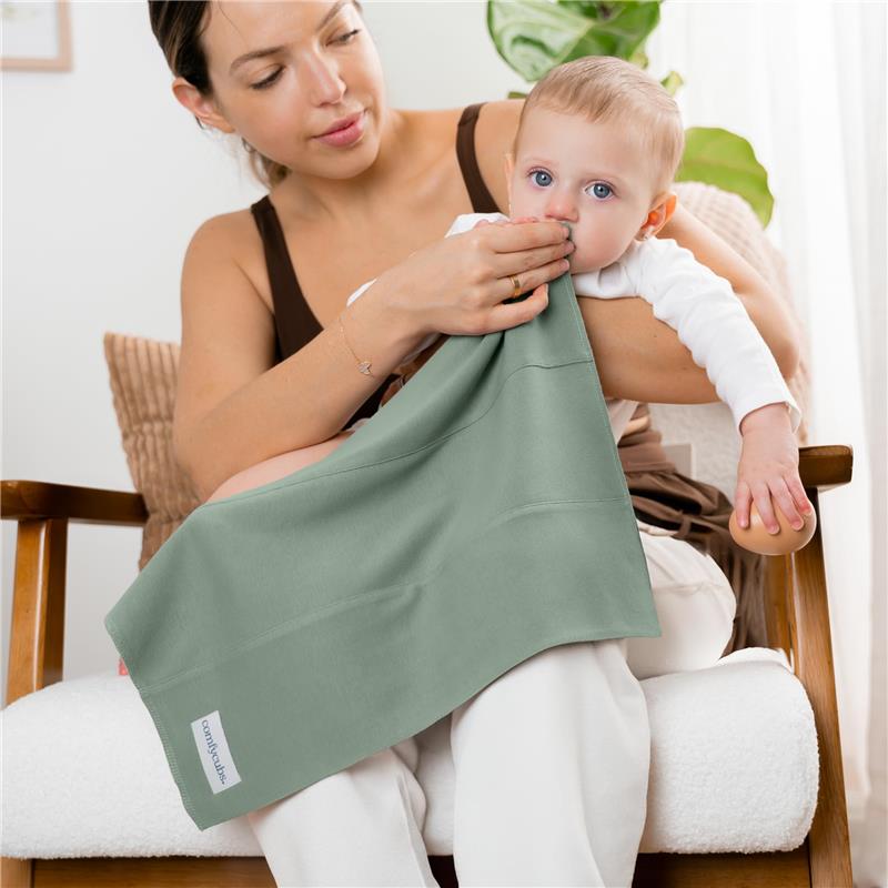 Mother holds a baby while using a soft, green burp cloth, showcasing its practical use.