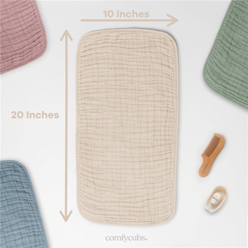 Muslin burp cloth from Comfy Cubs in sand color, measuring 10x20 inches, with additional colored cloths and a wooden comb nearby.