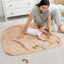 Muslin baby blanket in cream, with a mother and baby playing with wooden toys on it, creating a cozy playtime setting.
