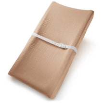 Muslin fitted changing pad cover in cedar color, featuring a textured surface and a white securing strap.