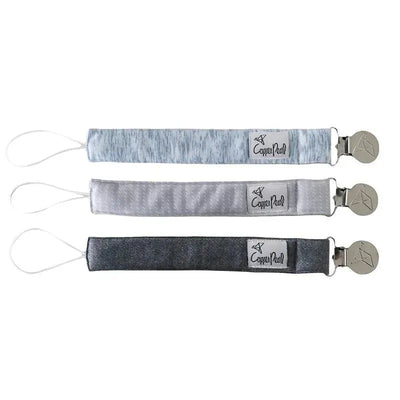 Three binky clips from the Copper Pearl Lennon set in varying shades of grey, each featuring a loop and a metal clip.