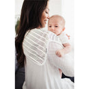 A smiling woman holds a baby on her shoulder, wearing a striped Copper Pearl burp cloth.