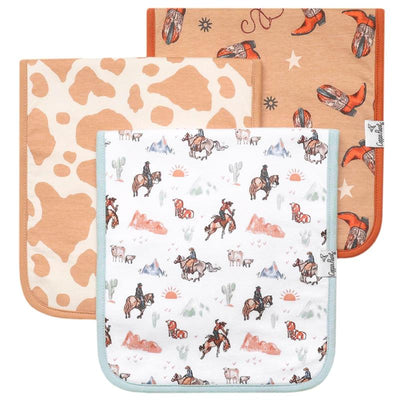 Three premium baby burp cloths from Copper Pearl, featuring cow print, cowboy boots, and western-themed illustrations.