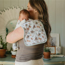 Premium baby burp cloths featuring a colorful goosie pattern, draped over a woman holding a baby.