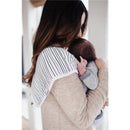 A woman holds an infant while wearing a striped Cotton burp cloth over her shoulder, showcasing the Copper Pearl brand.